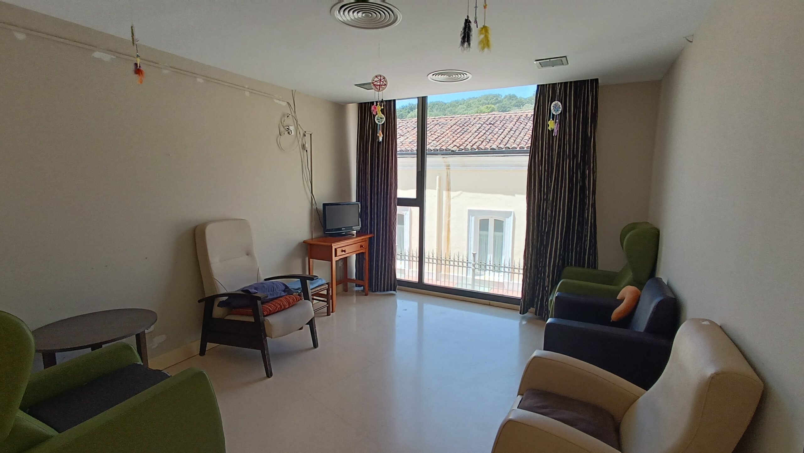 Zona social con mesas y sillas junto a la cafetería