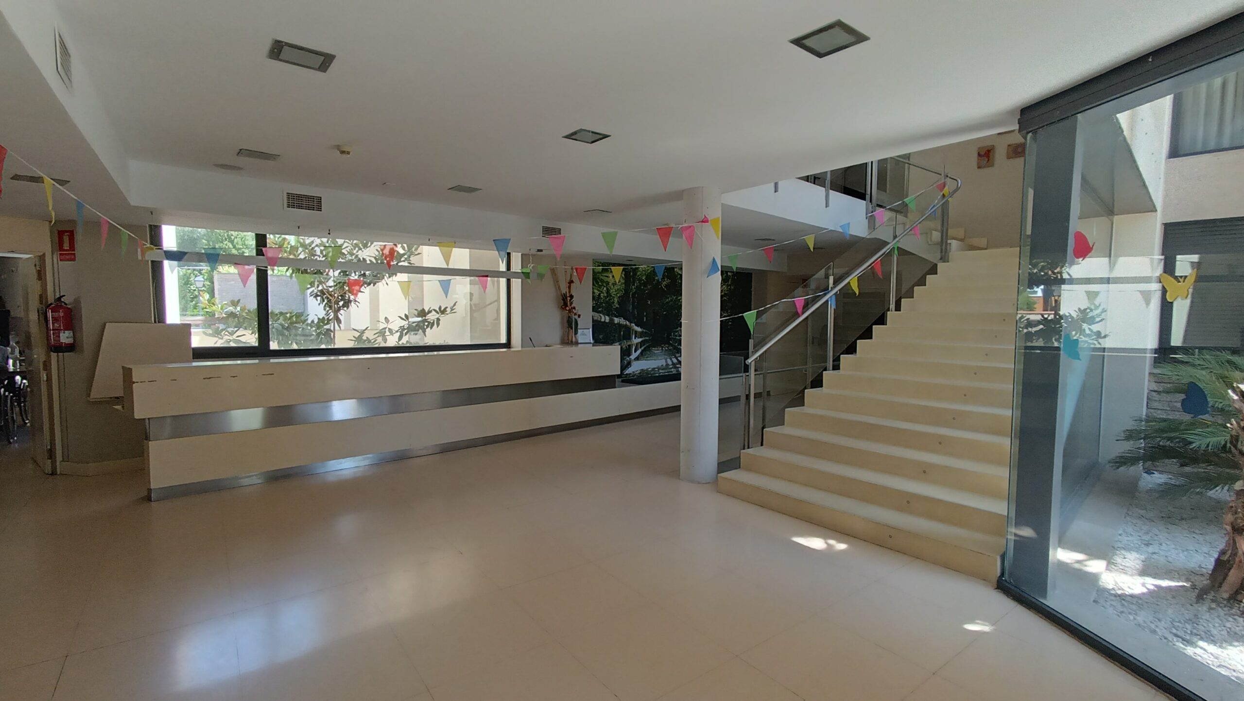 Hall de entrada luminoso con escalera y ventanales